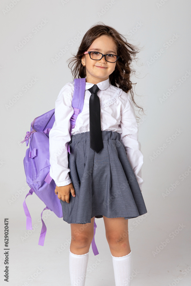 Back to school concept. Beautiful smiling and happy school little girl with backpack is posing on white background Back to school concept. Beautiful smiling and happy school little girl with backpack is posing on white background