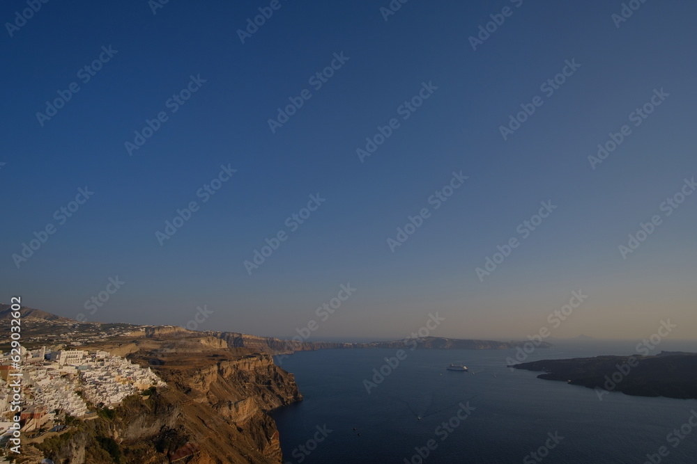 Beautiful cliff coastal landscape in Mediterranean Sea Santorini island skyline with blue quiet waters and sky in Greek Islands