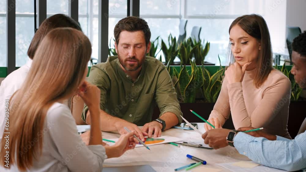 Office workers discuss documents working together at meeting