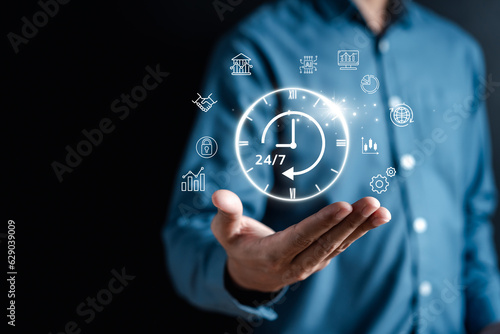 Nonstop service 24 hr concept. businessman hand holding virtual 24/7 with clock on hand for worldwide nonstop and full-time available contact of service concept. customer service.