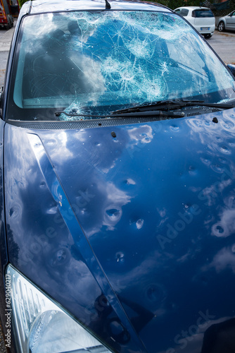 фотографія hail damage to car. damaged hood and windshield