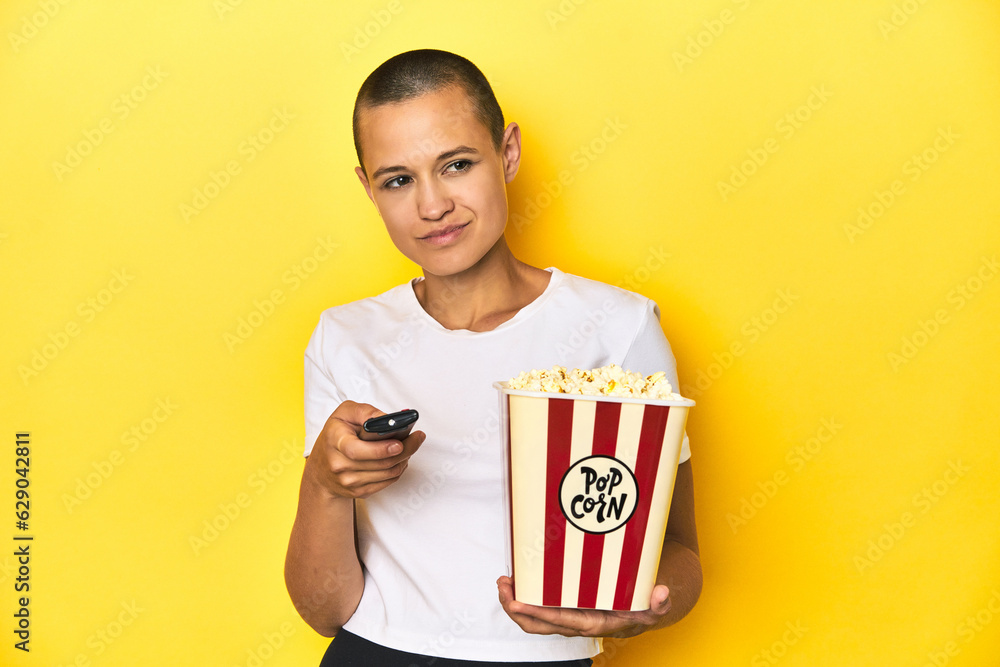 Woman with popcorn and TV remote, home cinema concept Woman with popcorn and TV remote, home cinema concept