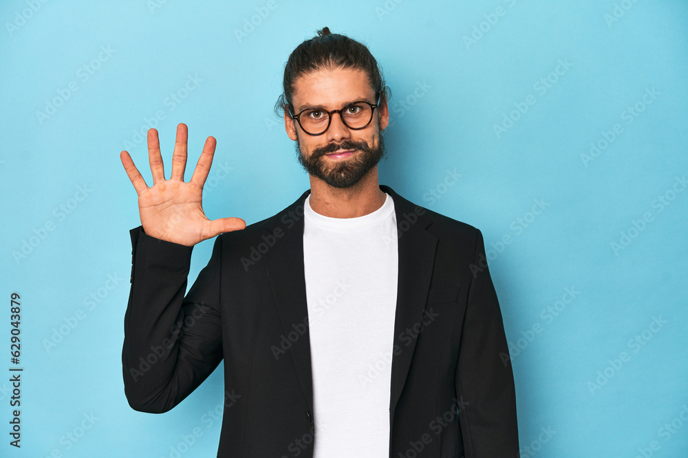 Businessman in suit with eyeglasses and beard smiling cheerful showing number five with fingers. Businessman in suit with eyeglasses and beard smiling cheerful showing number five with fingers.