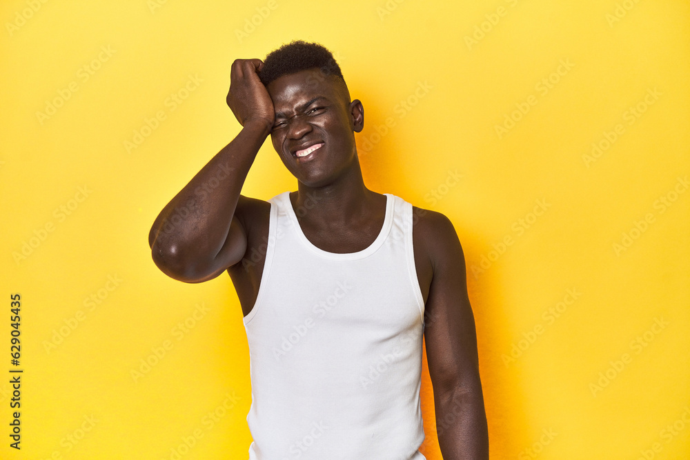 Stylish young African man on vibrant yellow studio background, tired and very sleepy keeping hand on head. Stylish young African man on vibrant yellow studio background, tired and very sleepy keeping hand on head.