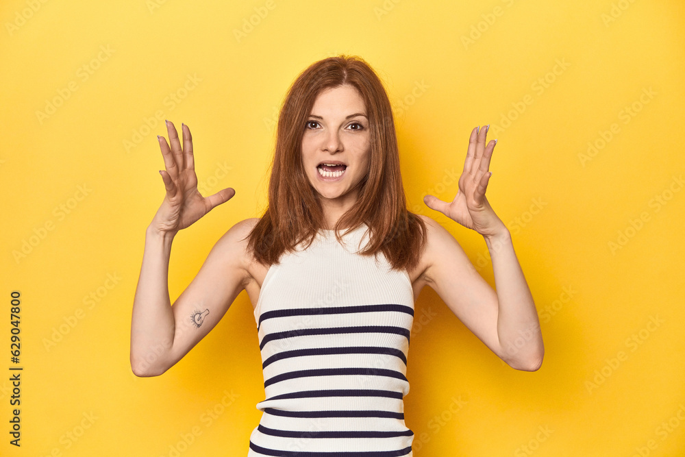 Redhead in a tank top, casual studio shot screaming to the sky, looking up, frustrated. Redhead in a tank top, casual studio shot screaming to the sky, looking up, frustrated.