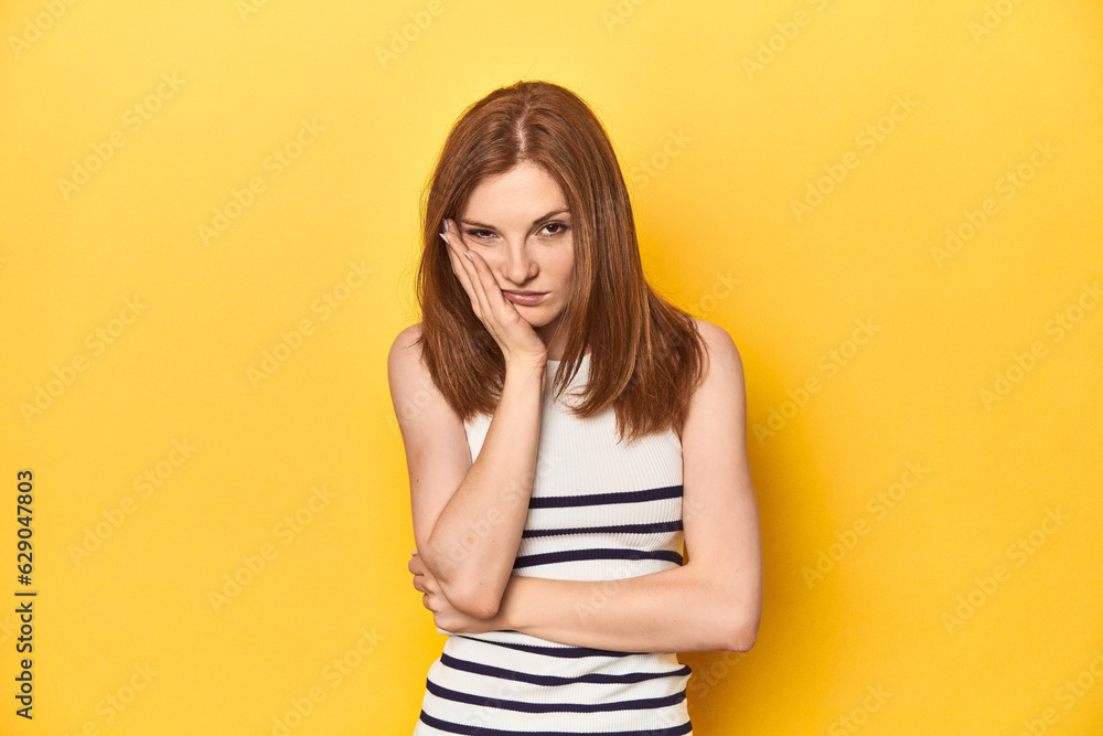 Redhead in a tank top, casual studio shot who is bored, fatigued and need a relax day. Redhead in a tank top, casual studio shot who is bored, fatigued and need a relax day.