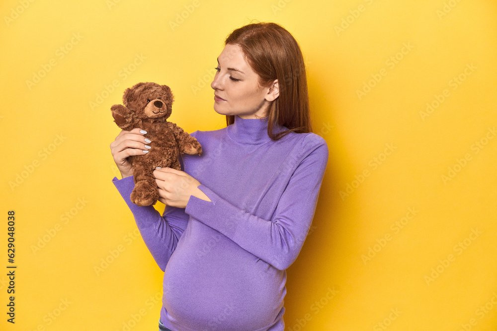 Pregnant redhead with teddy bear, awaiting baby's arrival. Pregnant redhead with teddy bear, awaiting baby's arrival.