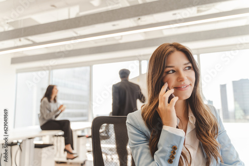 Beautiful confident businesswoman talking on mobile phone looking away