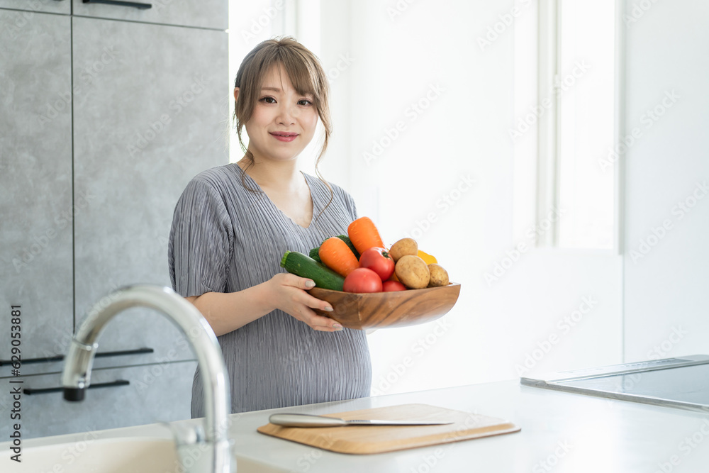 キッチンで野菜を持つアジア人女性・妊婦・プレママ
