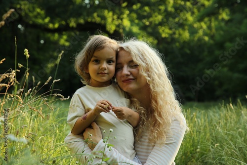Beautiful mother with her cute daughter spending time together outdoors