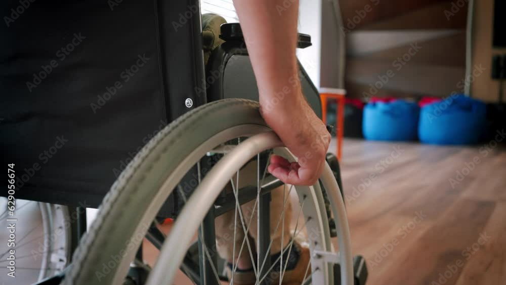 Man with spinal cord injury moves in wheelchair around room Man with spinal cord injury moves in wheelchair around room