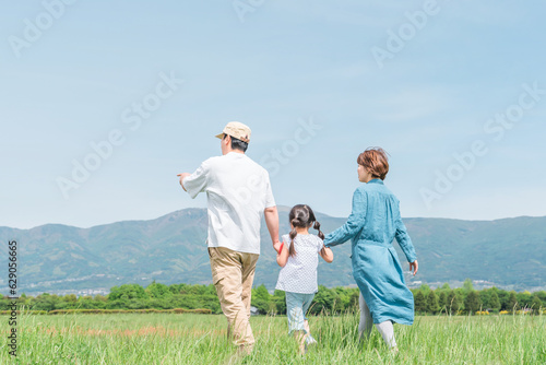 春・夏に公園・草原を歩く家族・ファミリーの後ろ姿（子供・両親・移住・田舎暮らし） 