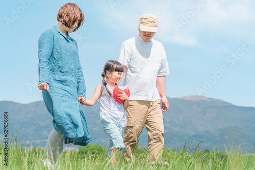 両親と手を繋いで歩く笑顔の子供 
