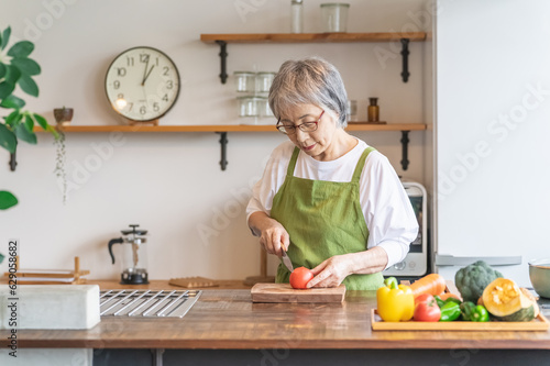 Foto 家のキッチンで料理を作るアジア人のシニア・高齢者女性