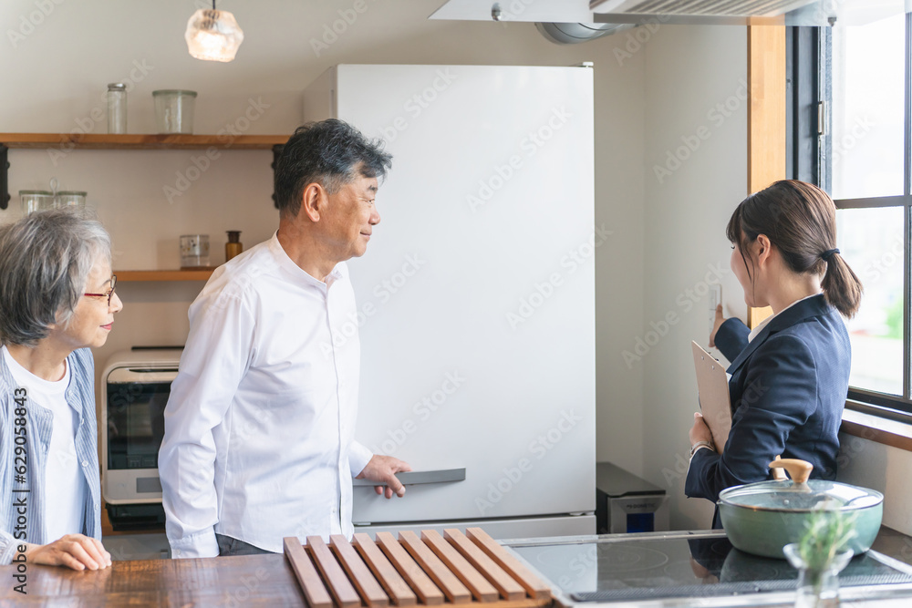 Fototapeta premium 家電量販店・住宅展示場・モデルルーム・電気屋で高齢者夫婦に説明するビジネスウーマン（電気） 