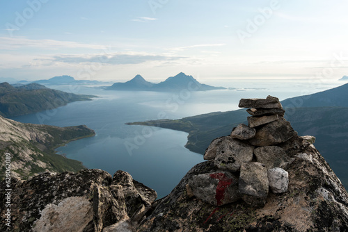 Afternoon view from Smaltinden, Luröy, Helgeland, NordNorge. View over Norwegian island of Tomma, across sjona. Mountains on islands in Norway. Tower of rocks in the foreground. Beautiful Norway hike.