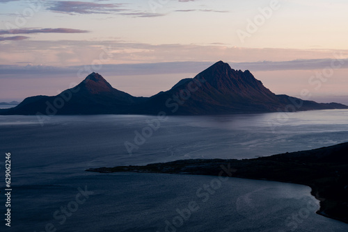 Dusk during arctic summer night over the mountain islands of Tomma, Helgeland, Norway. Dusk in norwegian archipelago. From Smaltind, Tortenviktind, Luröy, Nordnorge. Sunset norwegian coastline, fjell.