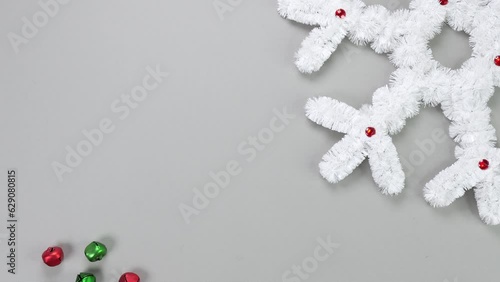 Fluffy white snowflake Christmas decor with moving gingle bells on a gray background. The concept of New Year and Christmas holidays, congratulations. Copy space. View from above. photo