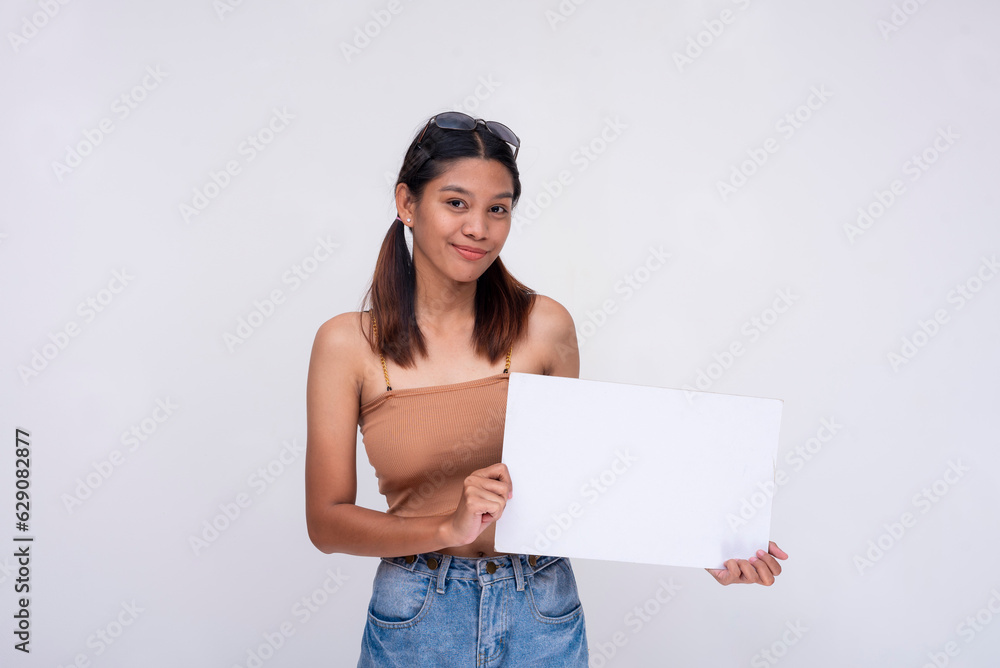 A smiling young Asian woman in pigtails smiling pleasantly while holding a white blank placard. Isolated on a white background. A smiling young Asian woman in pigtails smiling pleasantly while holding a white blank placard. Isolated on a white background.