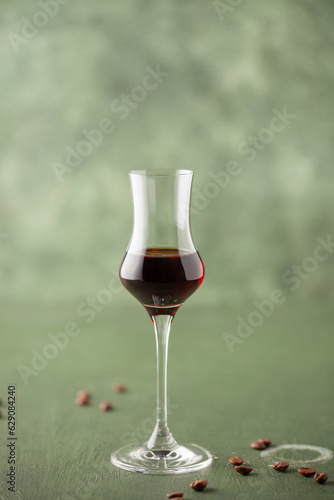 Foto Coffee liqueur in  stylish grappa glass and coffee beans on the table
