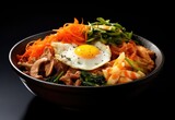 Bibimbap in a bowl, traditional Korean food, isolated on black background
