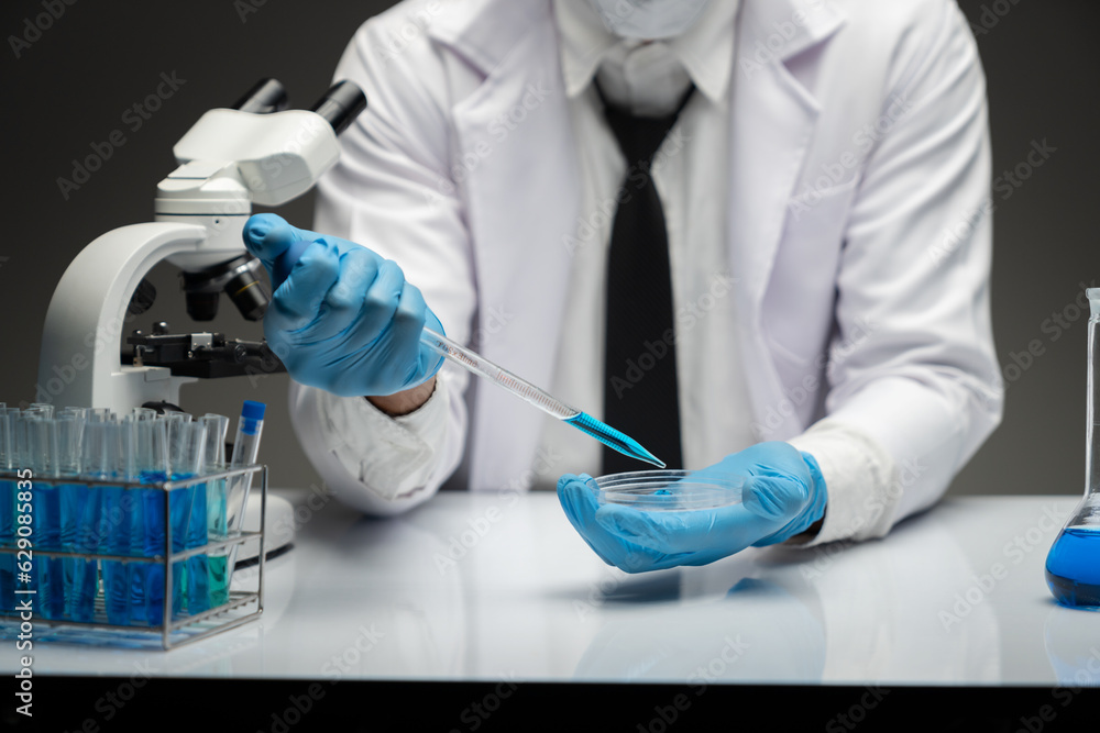 scientist Working in the laboratory using a Micro Pipette. Mixing liquid chemicals with genetically modified samples under a microscope biotechnology, microbiology development, research experiments. scientist Working in the laboratory using a Micro Pipette. Mixing liquid chemicals with genetically modified samples under a microscope biotechnology, microbiology development, research experiments.