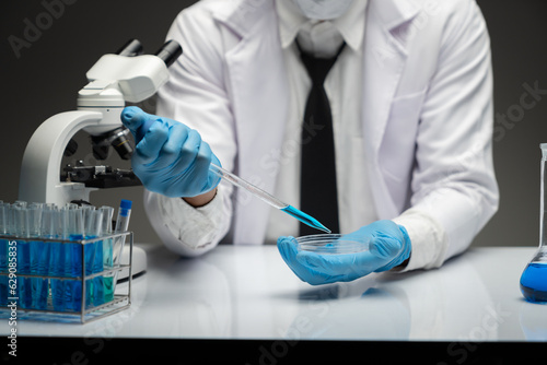 scientist Working in the laboratory using a Micro Pipette. Mixing liquid chemicals with genetically modified samples under a microscope biotechnology  microbiology development  research experiments.