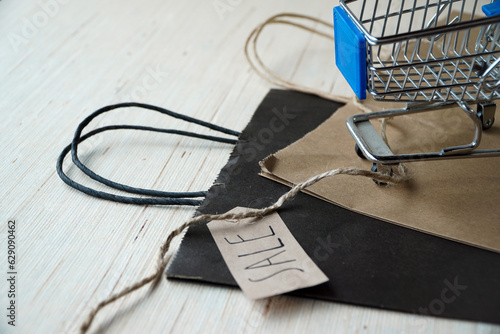 Sustainable Shopping: Recyclable Wrappings with Sale Tags and Mini Supermarket Cart. Eco-friendly choices for a guilt-free shopping experience. photo