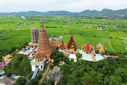 Wat Tham Sua on top hill with green rice fields and blue sky in Kanchanaburi Province Thailand. photo
