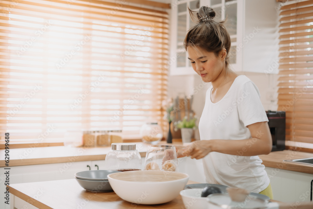 Asian wife cooking and prepare noodle meal for husband in the kitchen. Asian wife cooking and prepare noodle meal for husband in the kitchen.