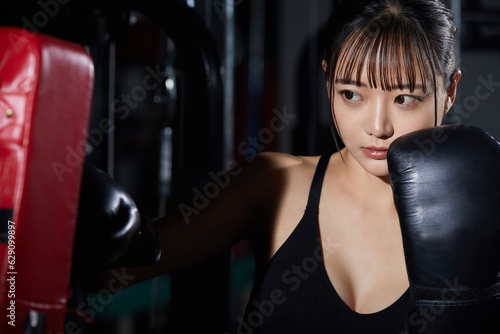 ジムでトレーニングをする若いアジアの女性 © K-Angle