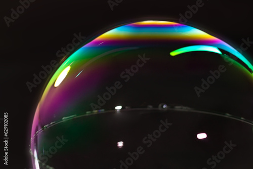 Canvas Print detail of colorful spheroid soap bubble in black background