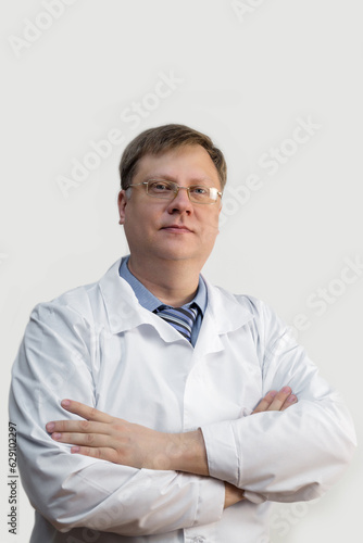 Adult male doctor blond in glasses white gray background.