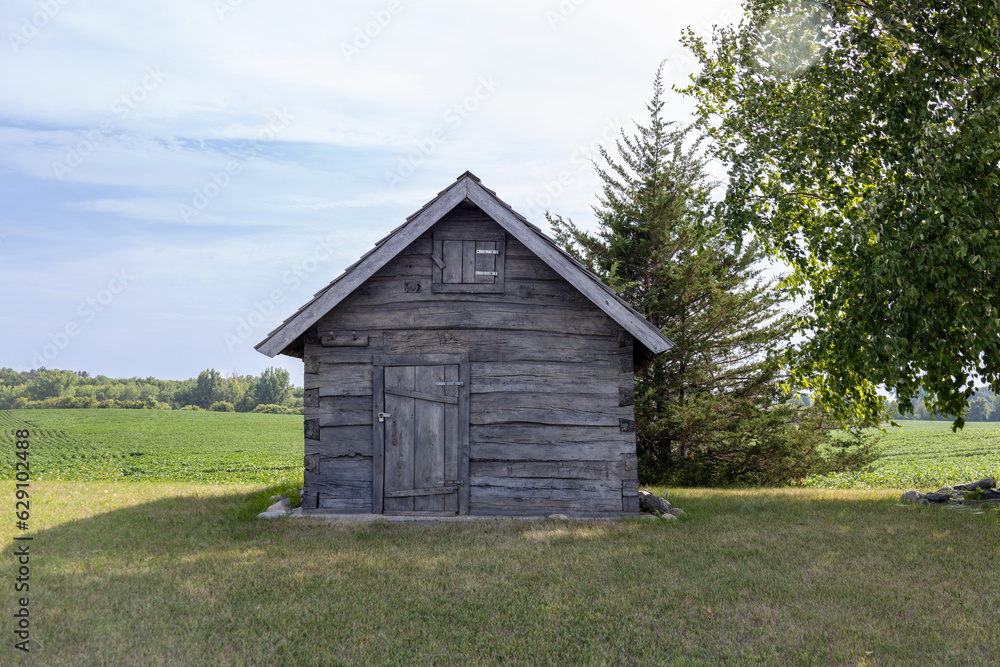 Rural landscape view of a 19th century log cabin on the prairie in midwestern United States