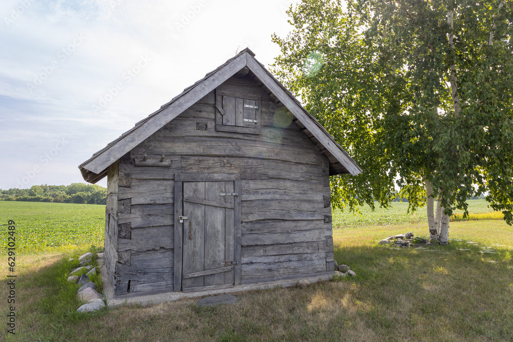 Rural landscape view of a 19th century log cabin on the prairie in midwestern United States Rural landscape view of a 19th century log cabin on the prairie in midwestern United States
