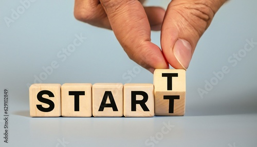 Placing a wooden block with the text "START" on a wooden table. on a Grey background. Business concept for a successful growth process.