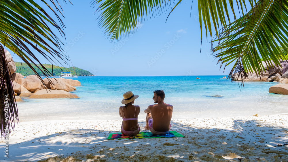 Fototapeta premium a young couple of men and women on a tropical beach during a luxury vacation in the Seychelles. Tropical beach Anse Lazio Praslin Seychelles Islands