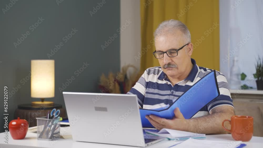Home office worker old man reviewing paperwork files. Home office worker old man reviewing paperwork files.