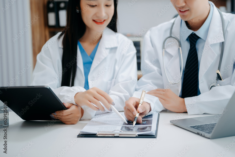 Portrait of Asian doctor speaking to colleagues during medical meeting in conference room or Medical Laboratory Portrait of Asian doctor speaking to colleagues during medical meeting in conference room or Medical Laboratory