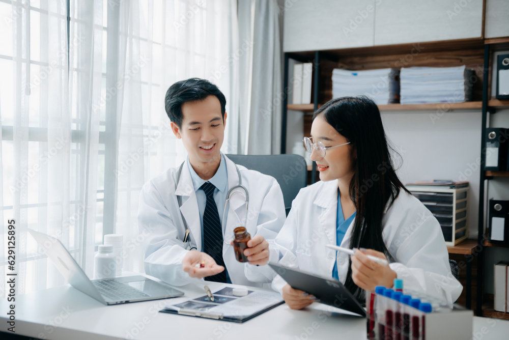 Portrait of Asian doctor speaking to colleagues during medical meeting in conference room or Medical Laboratory Portrait of Asian doctor speaking to colleagues during medical meeting in conference room or Medical Laboratory