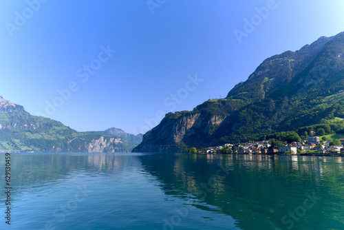 Scenic view of Lake Lucerne with Swiss Alps and mountain panorama seen from lakeshore of village Flüelen on a sunny spring day. Photo taken May 22nd, 2023, Flüelen, Switzerland. © Michael Derrer Fuchs