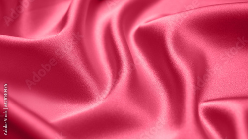 Viva Magenta toned red magenta fabric atlas. Close up pink silk satin texture for sewing. Abstract background wallpaper. Twisted folds cloth. Trendy color of the year 2023. Fashion color pattern 