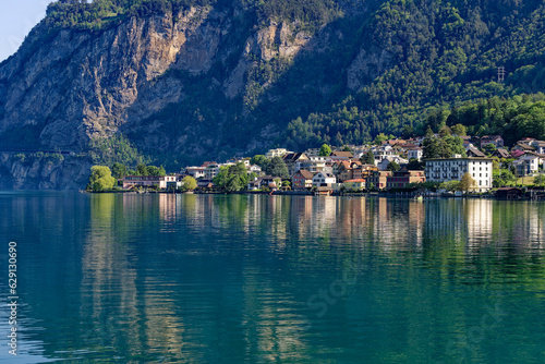 Scenic view of Swiss village of Flüelen with beautiful reflections in water on a sunny spring morning. Photo taken May 22nd, 2023, Flüelen, Canton Uri, Switzerland. © Michael Derrer Fuchs