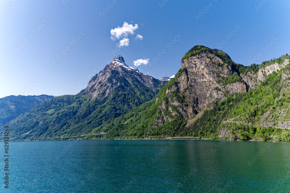 Scenic landscape in the Swiss Alps with Lake Lucerne in the foreground and mountain panorama in the background on a sunny spring day. Photo taken May 22nd, 2023, Lake Uri, Switzerland.