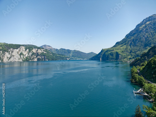 Scenic view of Lake Lucerne with Swiss Alps and mountain panorama with City of Brunnen in the background on a sunny spring day. Photo taken May 22nd, 2023, Lake Uri, Switzerland.
