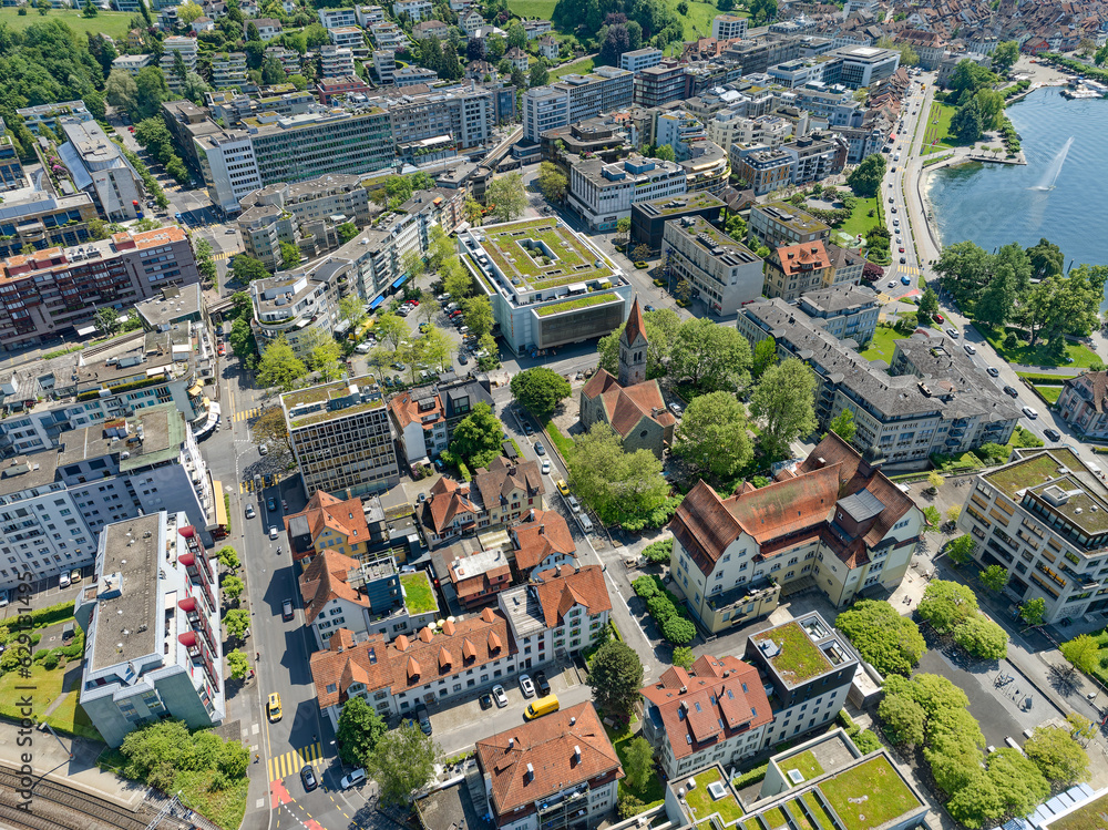 Aerial view of Swiss City of Zug with cityscape and church on a sunny spring day. Photo taken May 22nd, 2023, Zug, Switzerland.
