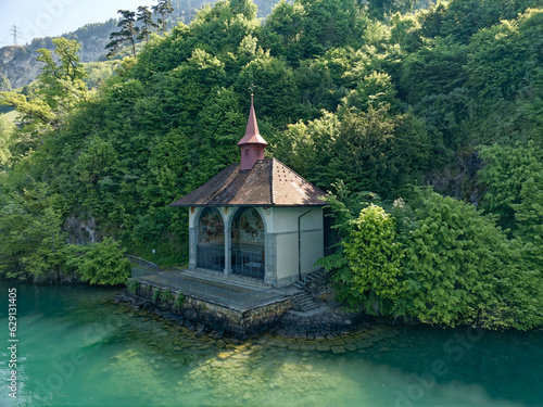 Famous Tell's Chapel at lakeshore of Lake Uri on a sunny spring day with woodland in the background. Photo taken May 22nd, 2023, Sisikon, Canton Uri, Switzerland. © Michael Derrer Fuchs