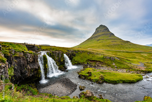Mount Kirkjufell and Kirkjufellsfoss in Iceland in the summer. 