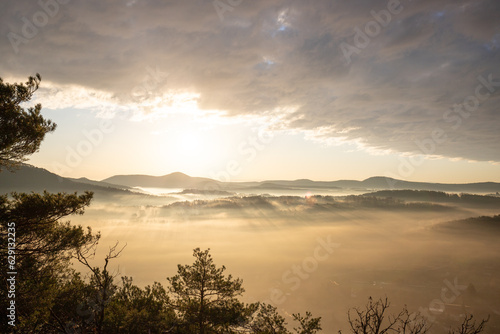 Mystical Sunrise at Wachtfelsen, Palatinate Forest. Captivating landscape shot amidst fog and clouds near Wernersberg, Germany photo