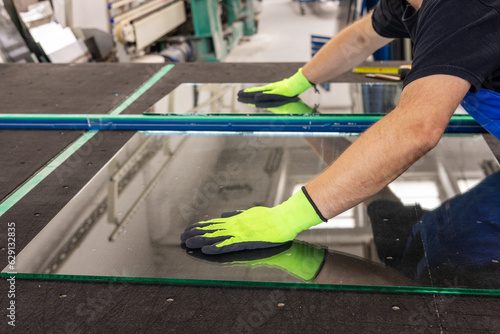 A glazier breaks a panel of glass on a special table in a glass factory, close up